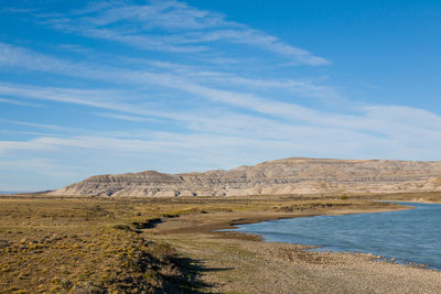 Scenic view of land and mountains against sky