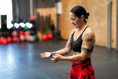 Side view of young woman exercising in gym