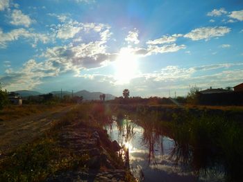 Scenic view of field against cloudy sky