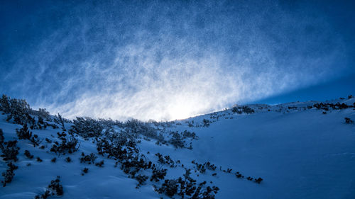 Scenic view of snowcapped mountains against blue sky