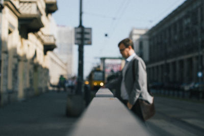 Side view of man walking on street in city