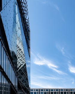 Low angle view of modern building against cloudy sky