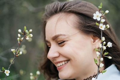 Portrait of a beautiful smiling joyful girl in cherry blossoms in spring