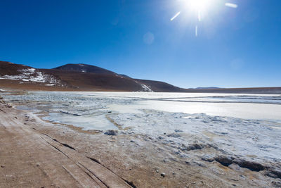 Scenic view of snowcapped mountains against blue sky