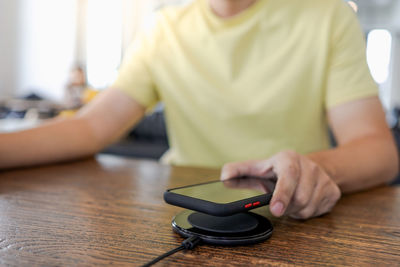 Close-up of boy holding camera while sitting on table