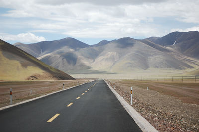 A newly built flat asphalt road leads to the beautiful mountains ahead