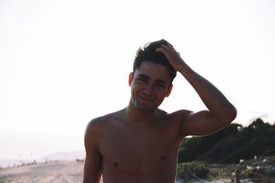 Portrait of shirtless man standing at beach