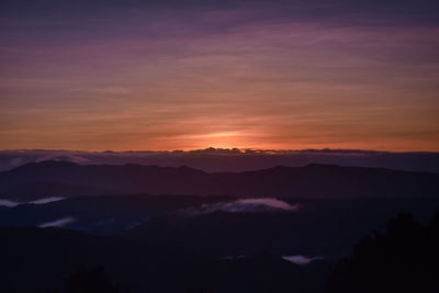 Scenic view of silhouette mountains against romantic sky at sunrise