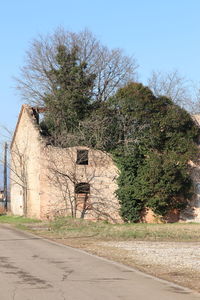 Road by building against clear sky