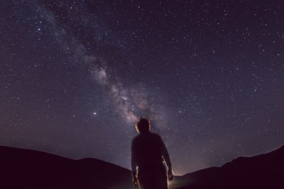 Silhouette woman standing against star field at night