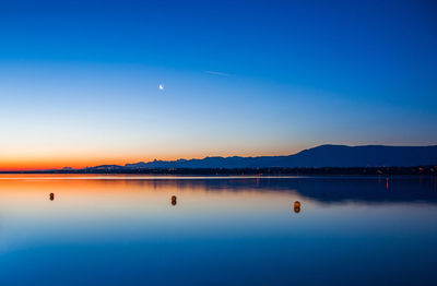 Scenic view of calm lake against sky during sunset