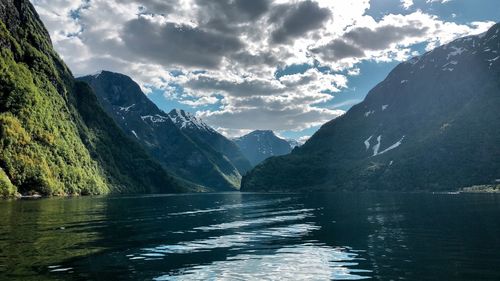 Scenic view of lake by mountains against sky