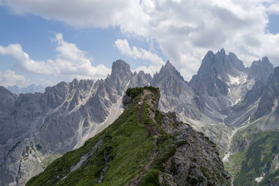 Woman walking towards the mountain top overlooking cadini group mountains