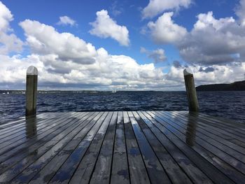 Wooden pier over sea against sky