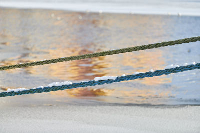Two ropes on background of sea water in winter. ropes hanging from fishing ship or yacht, close up.