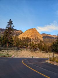 Road by mountains against blue sky