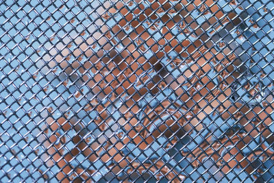 Abstract metal mesh fence closeup blue colored for banner with empty space for text