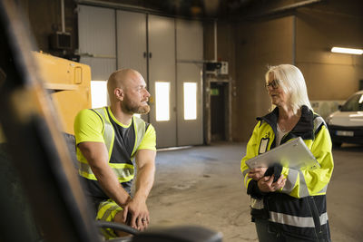 Male and female colleagues working in workshop