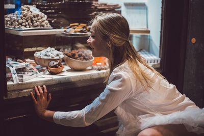 Side view of woman sitting on table