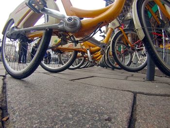 Close-up of bicycle parked on sidewalk by road in city