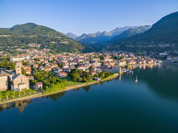 Aerial view of townscape by mountain against sky