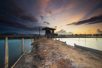 Pier amidst sea against sky during sunset