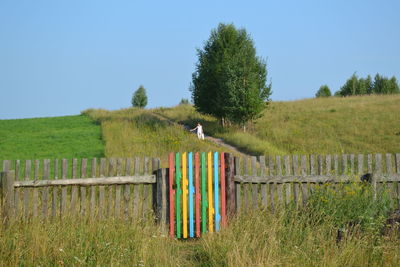 Wooden fence on field against sky