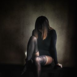 Woman sitting against wall