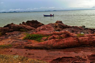 Scenic view of rocks on sea against sky
