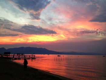 Scenic view of sea against cloudy sky at sunset