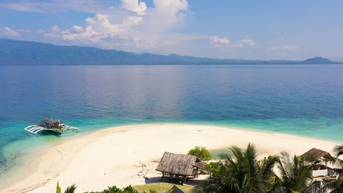 Perfect beach with blue water and white sand. boat off the coast of a tropical island.