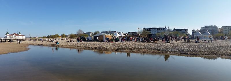 People on beach against clear sky