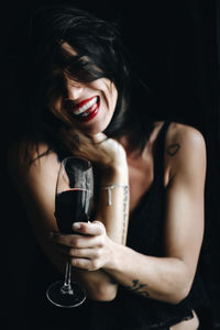 Close-up of a smiling young woman holding drink