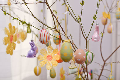 Close-up of easter eggs hanging by twigs at home