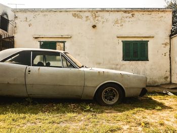 Abandoned car against building