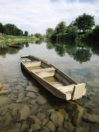 Boat moored on lake against sky