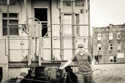 Portrait of man standing against abandoned train