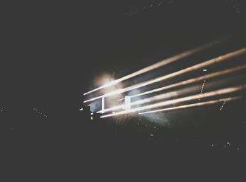 Close-up of illuminated stage against sky at night