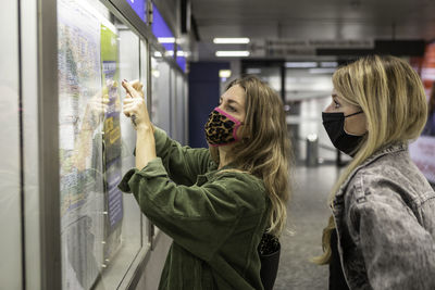 Side view of young woman standing in train