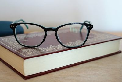 Close-up of eyeglasses and book on table