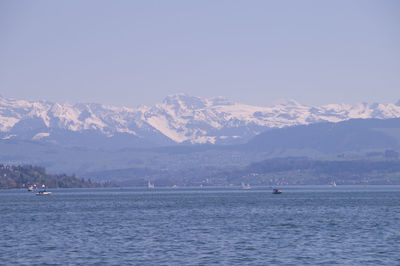 Scenic view of sea and mountains against sky