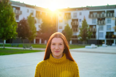 Portrait of smiling woman against building in city