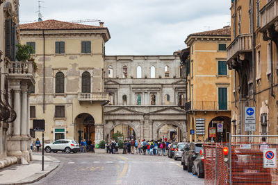 People on street amidst buildings in city