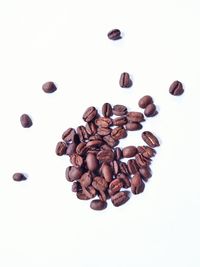 High angle view of coffee beans against white background