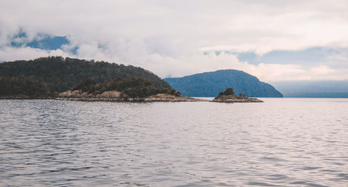 Scenic view of sea and mountains against sky