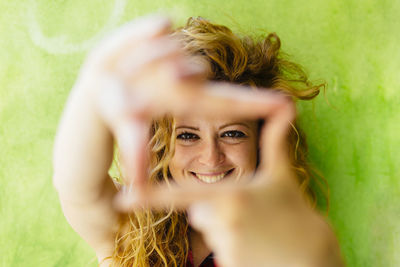 Portrait of smiling woman shaping a finger frame