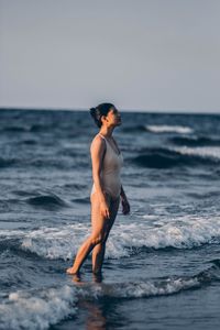 Full length of young woman standing on beach