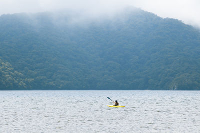 Man surfing on sea against sky