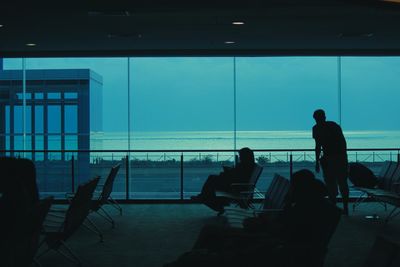 Silhouette people sitting at airport