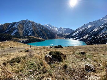 Scenic view of lake and mountains against blue sky